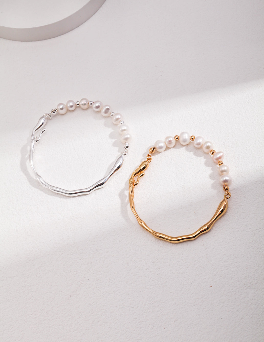 Stylish bangles with pearls, one half gold plated and the other half freshwater pearls bracelet, the other bangle in silver.