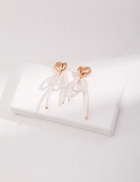 Stunning statement pearl earrings resting on a clean white surface, highlighting their elegance and timeless appeal.