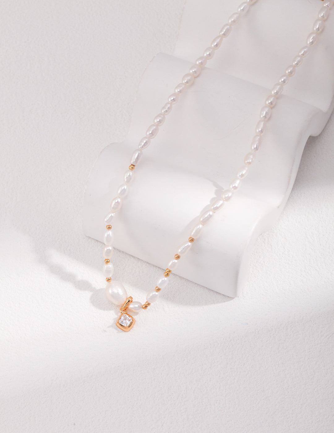 A stunning freshwater pearl necklace with a delicate gold chain and a lustrous pearl bead.