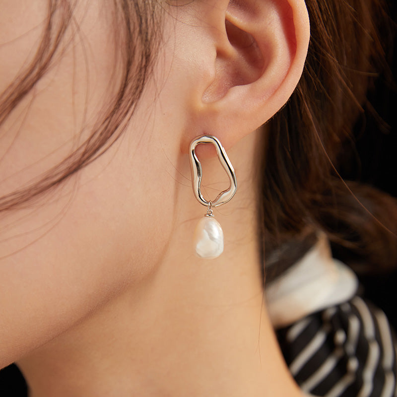 Sterling silver earrings with a small pearl on the end. Baroque pearls add a unique touch to this elegant accessory.