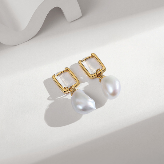 Gold hoop earrings adorned with two exquisite white baroque pearls.