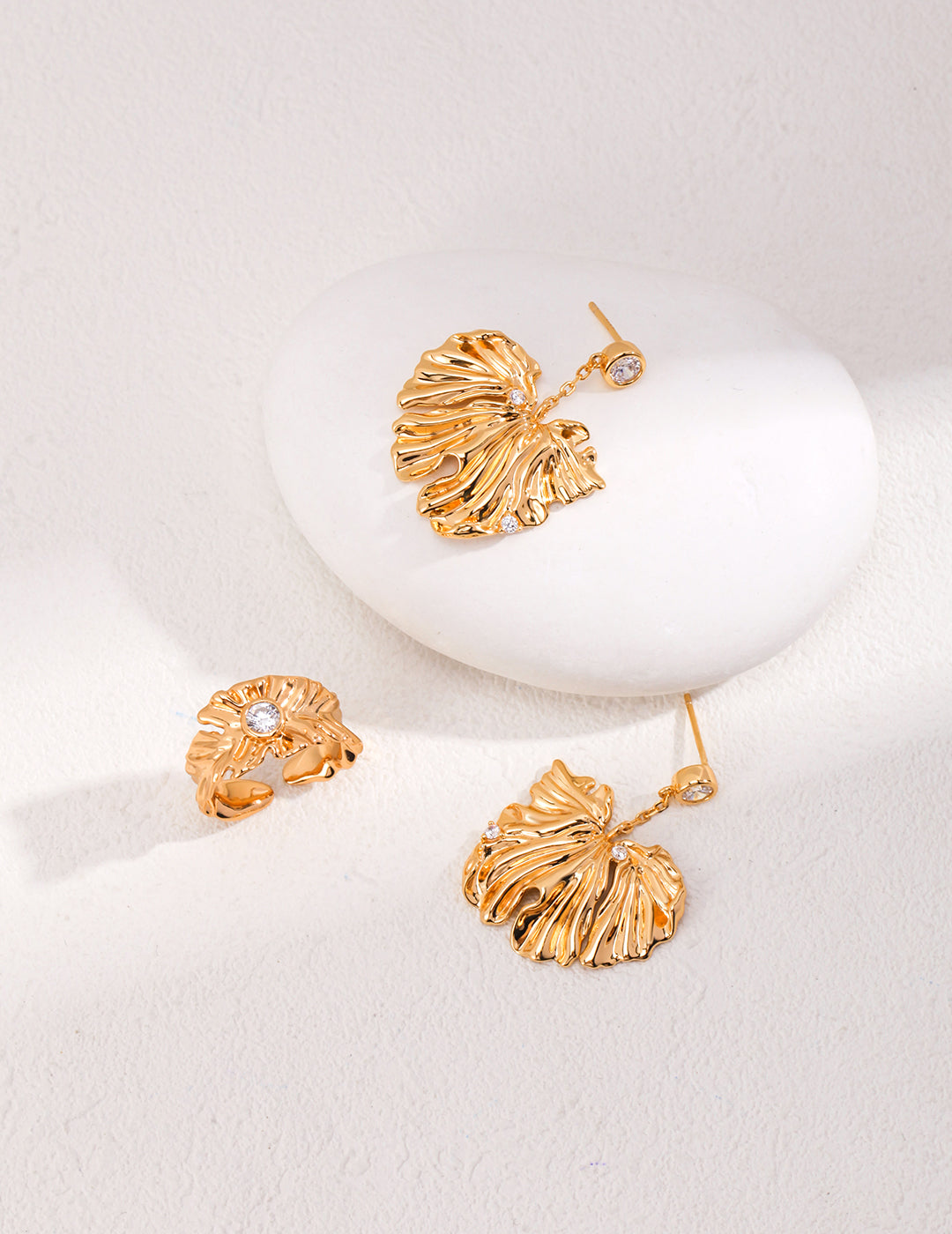 Two gold plated earrings with leaf-like dangles, complemented by a matching ring.