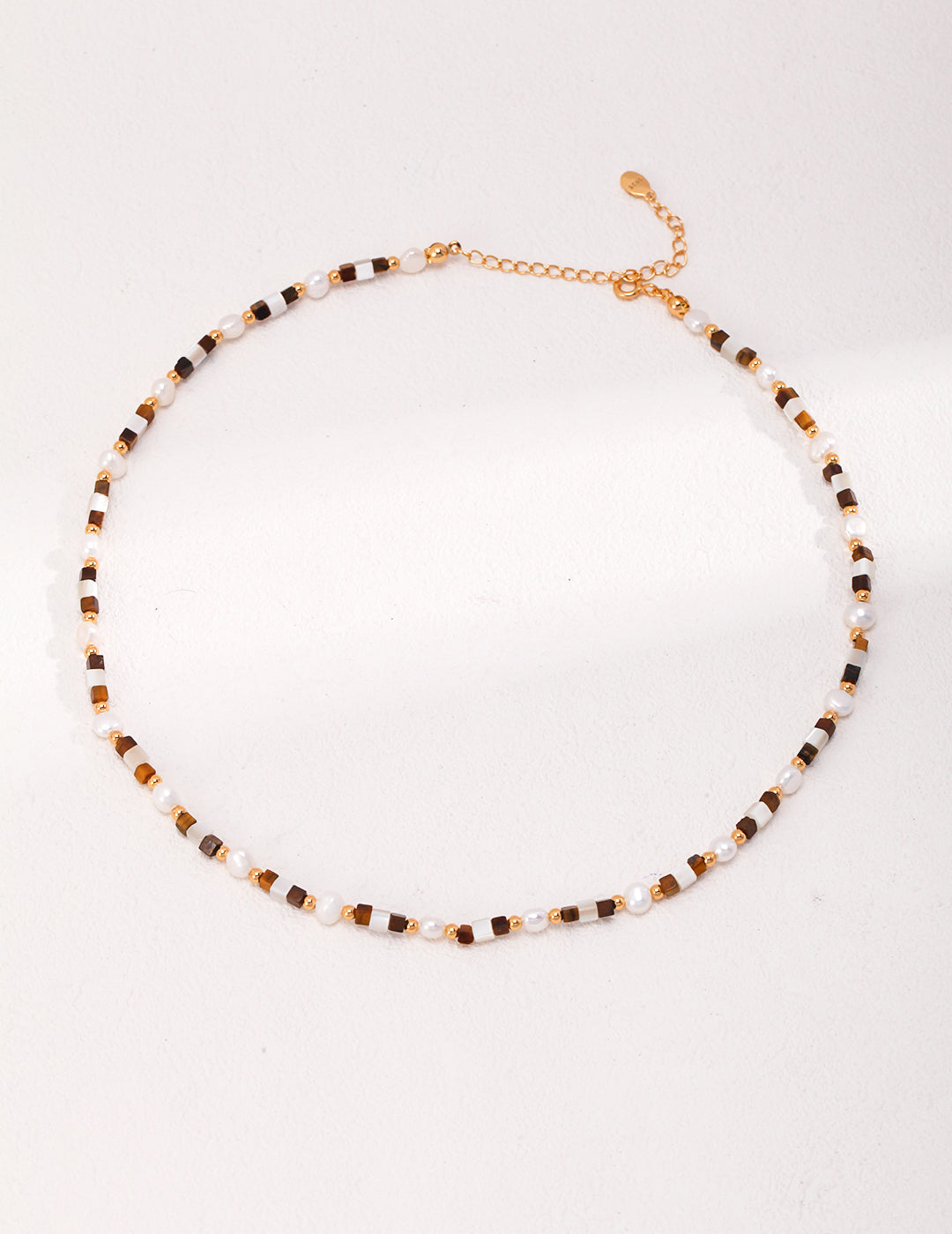 Chic gold and black beaded necklace with tiger's eye nacre details, ideal for adding a touch of elegance to your outfit.