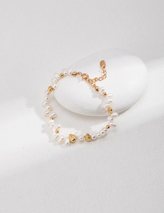 A bracelet with gold beads and pearls, adding elegance and sophistication to any outfit.