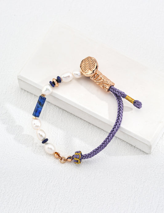 Elegant hemp rope bracelet featuring gold clasp, blue bead, pearls, and lapis lazuli.