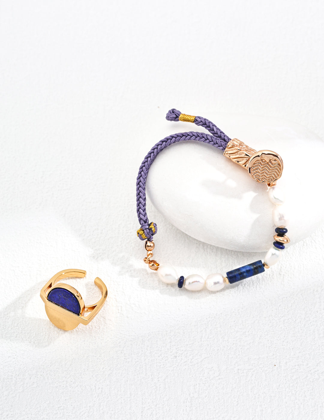 Blue and gold hemp rope bracelet with pearl and lapis lazuli bead, accompanied by a gold ring.