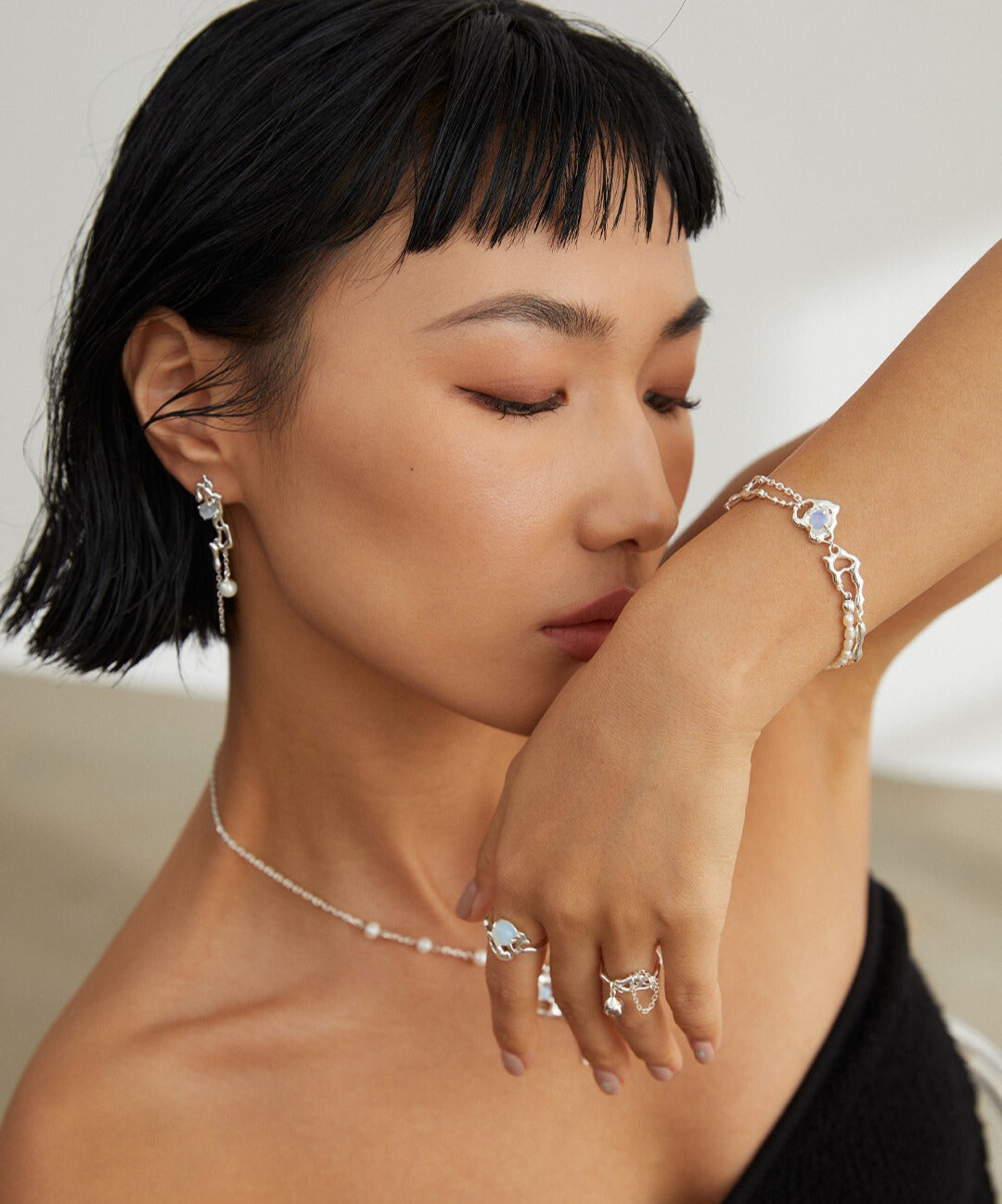 Elegant woman adorned in silver accessories with opal.