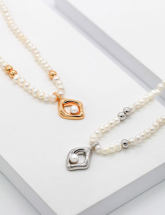 Stylish silver and gold necklaces adorned with pearls and charms.