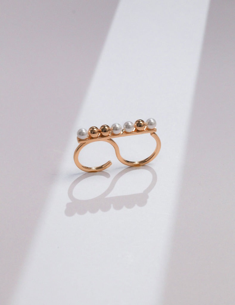 Chic gold two-finger ring featuring delicate pearls, adding a touch of glamour and elegance to your jewelry collection.