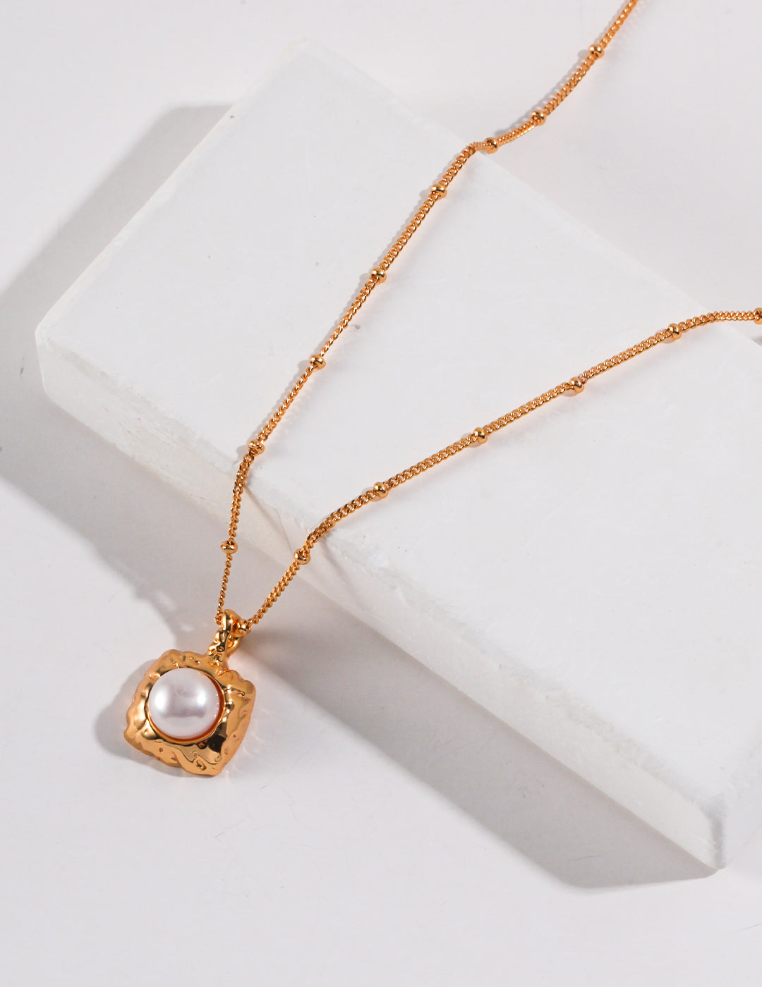 A stunning gold plated necklace with a square freshwater pearl pendant, adding elegance to any outfit.