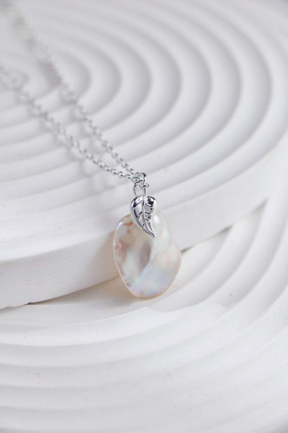 Beautiful pearl petal necklace with a prominent white pearl, elegantly displayed on a white background.