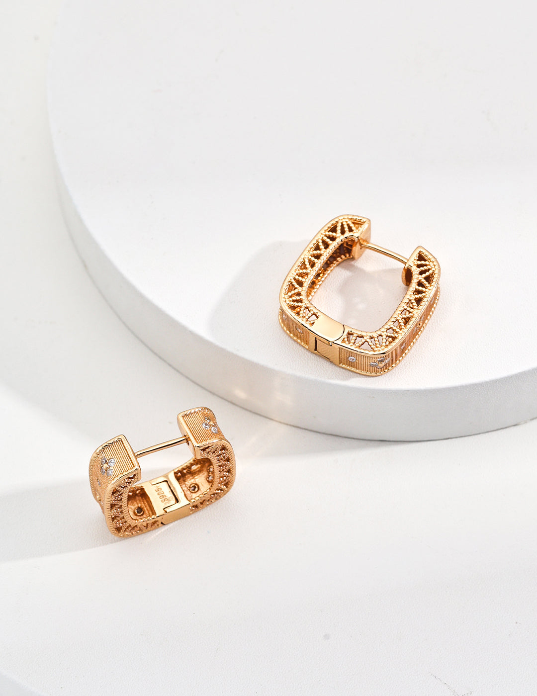 Elegant gold tone earrings adorned with sparkling zirconia, showcasing a luxurious and timeless design.