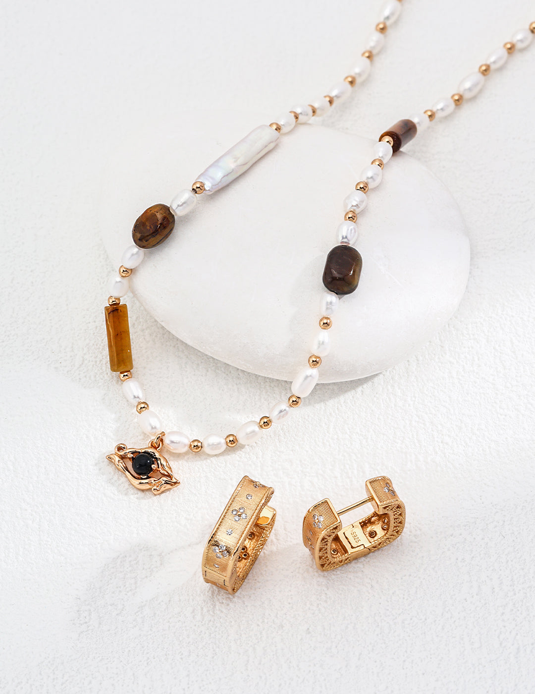 Beautiful gold jewelry set with a striking stone, including a necklace and matching earrings for a sophisticated look.