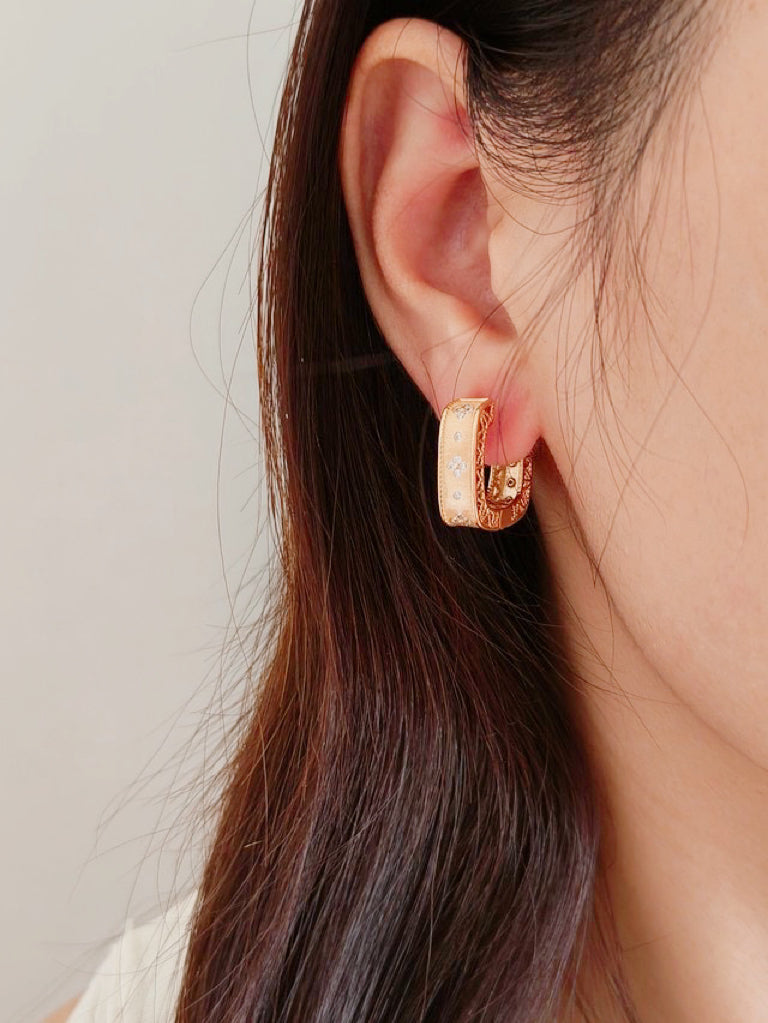 Close-up of a woman with a striking gold hoop earring, enhancing her fashionable appearance.