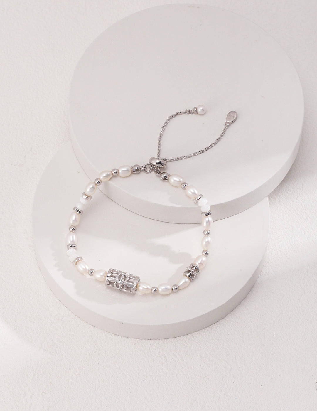 A silver bracelet adorned with freshwater pearls and cubic zirconia.