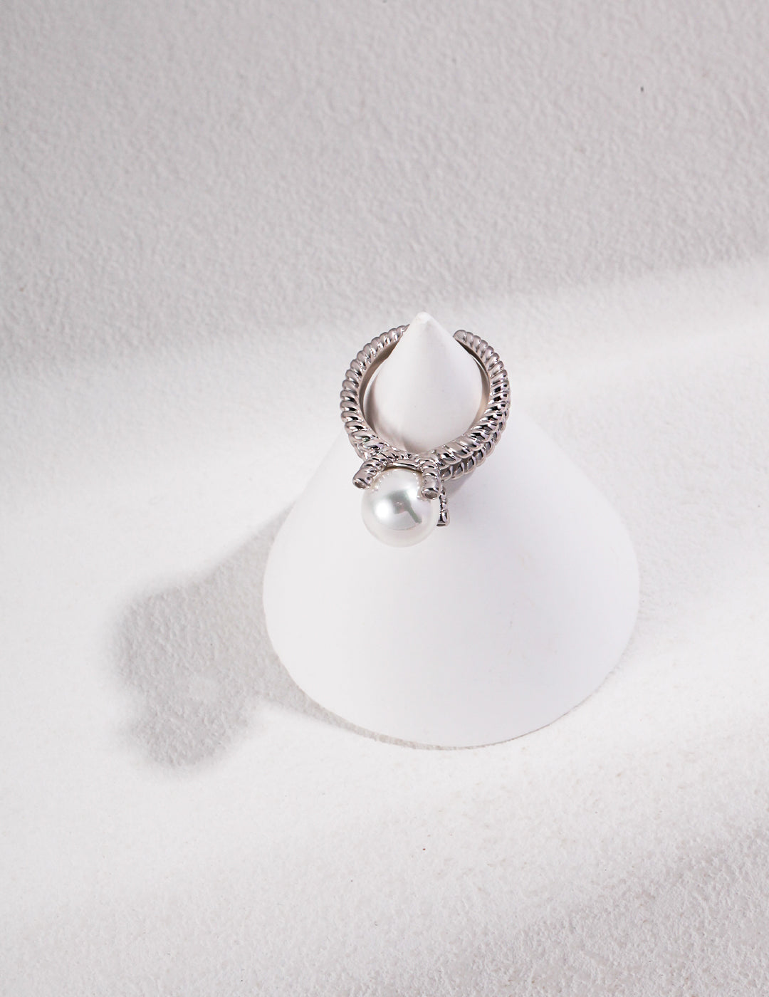 Silver band ring featuring white shell pearl.