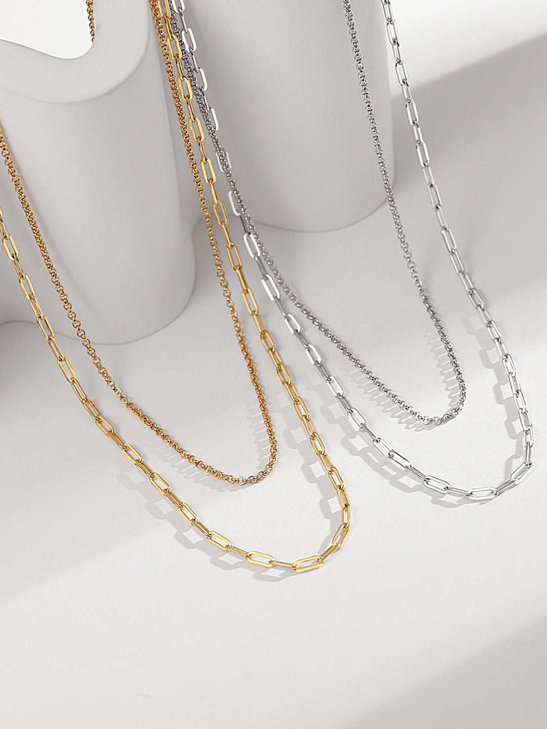 Assortment of chain necklaces: silver and gold double layer chains showcasing diverse styles.