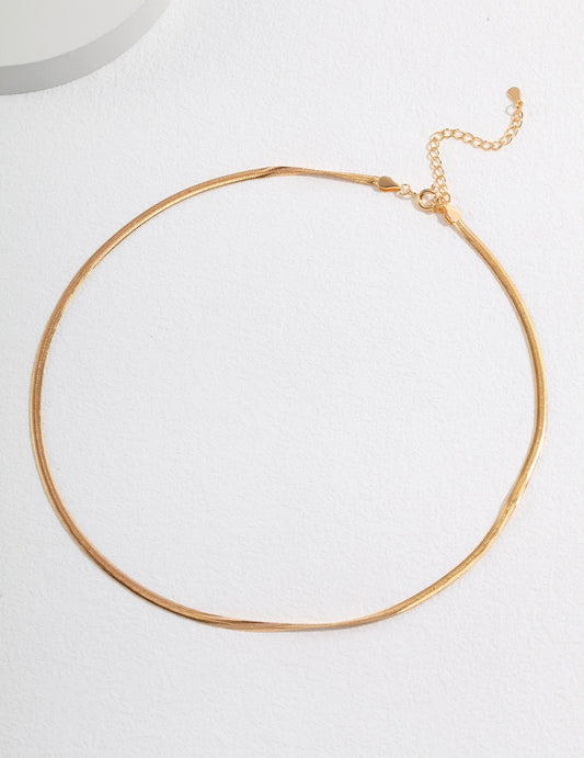 Shiny gold chain choke necklace on white background.