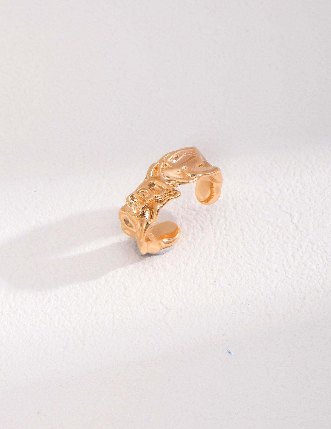 Textured gold ring featuring leaf motif.