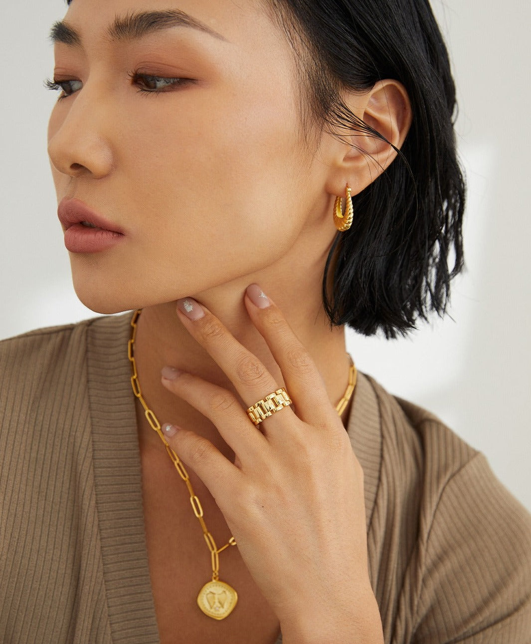 A woman wearing elegant gold jewelry, including a necklace and earrings, adding a touch of sophistication to her attire.