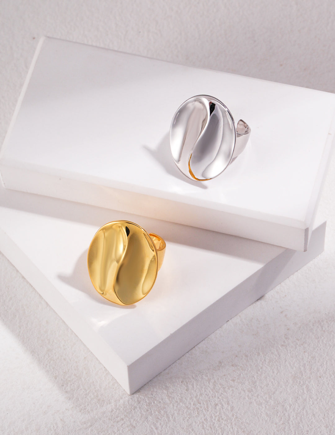 Coffee bean design gold and silver rings displayed on a white box.