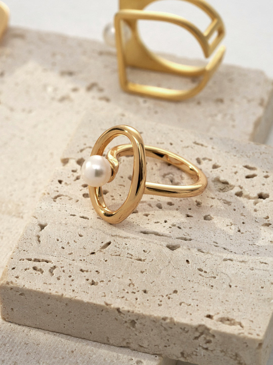 Mezuille Sloane organic gold ring featuring a floating pearl in an open-frame oval on a stone pedestal.