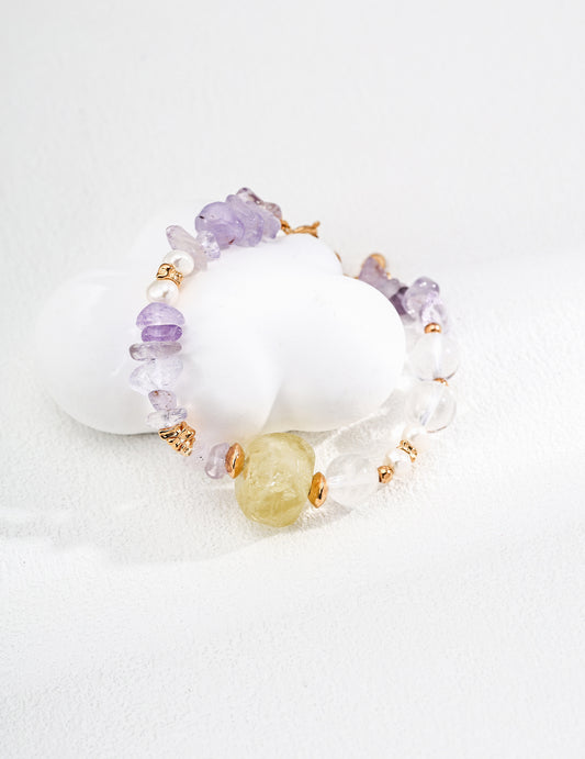 Beaded bracelet featuring Citrine, Clear Quartz beads, and an Amethyst stone on a white background.