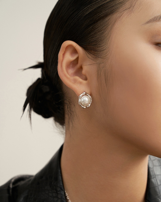 A woman models sunny side up pearl earrings, showcasing elegance and style with a classic pearl earring look.