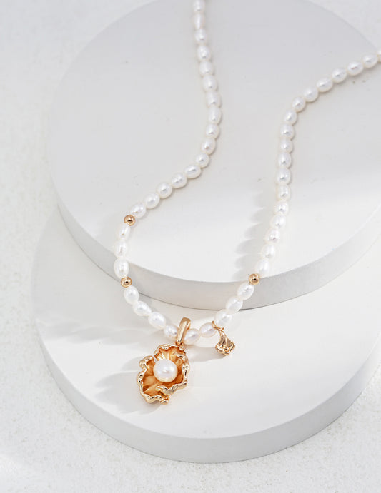 Elegant pearl necklace featuring a stunning gold charm resting on top, showcasing a perfect blend of sophistication and style.