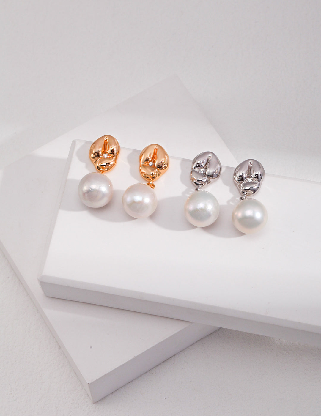 Two pairs of silver and gold plated pearl drop earrings, each with a beautiful pearl suspended below.