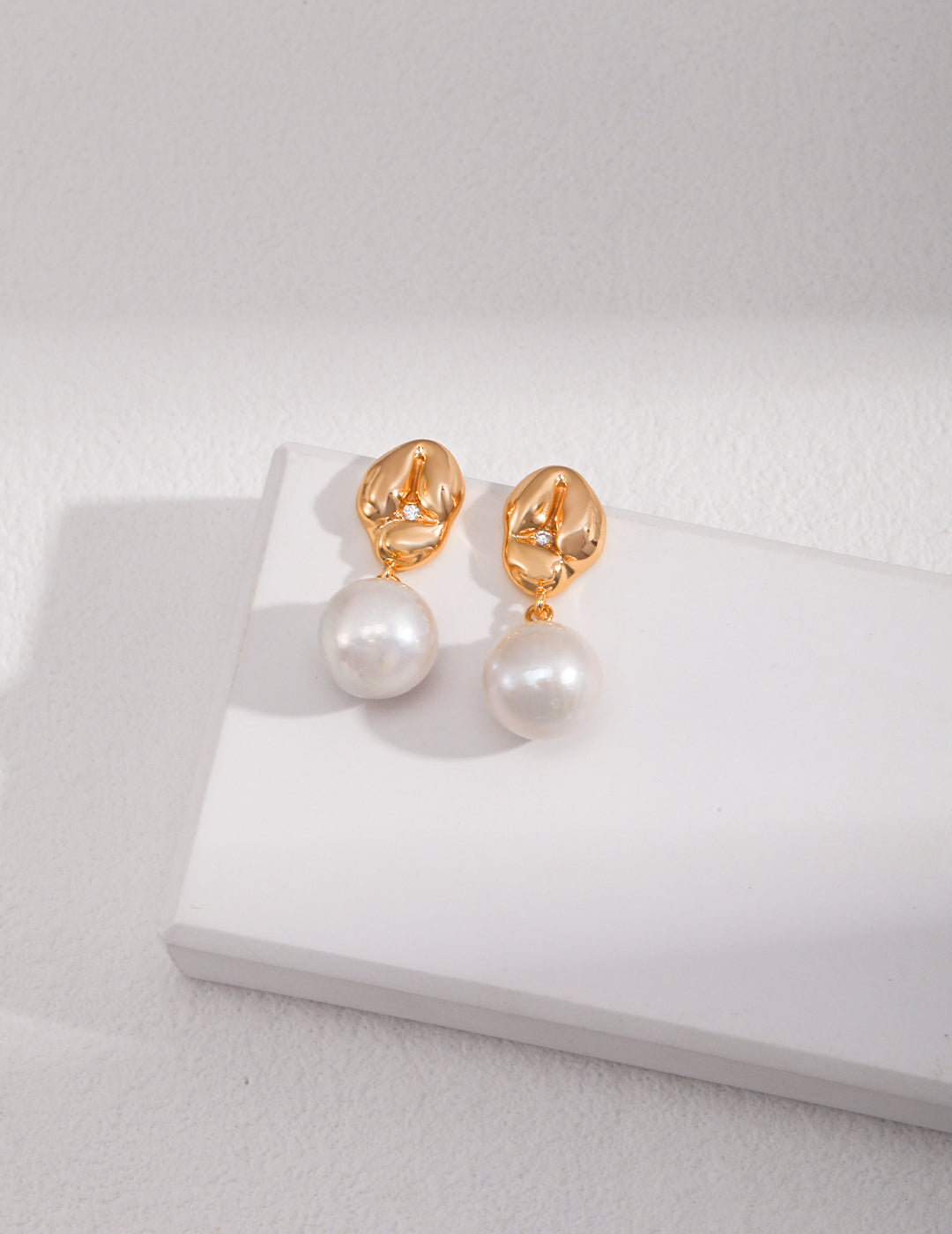 Gold plated pearl drop earrings with lustrous white pearls, adding elegance and sophistication to any outfit.