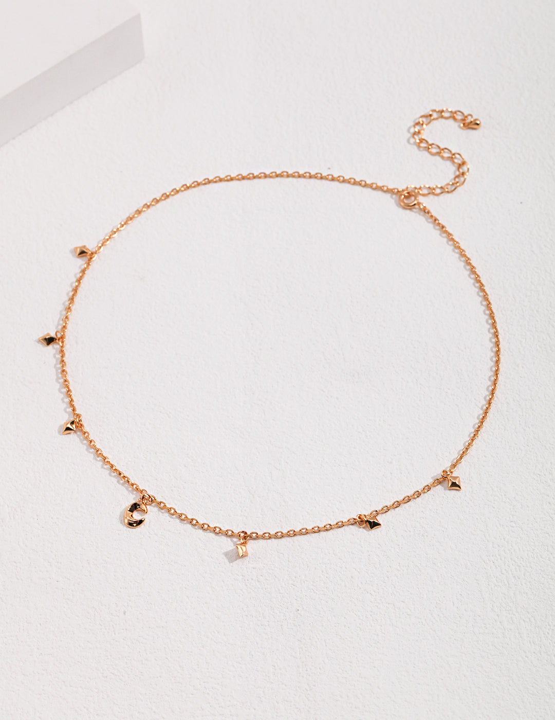 A delicate gold chain necklace with celestial charms.