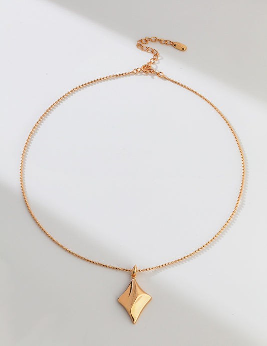 A stunning gold necklace with a diamond pendant, complemented by a star pendant on a gold chain.