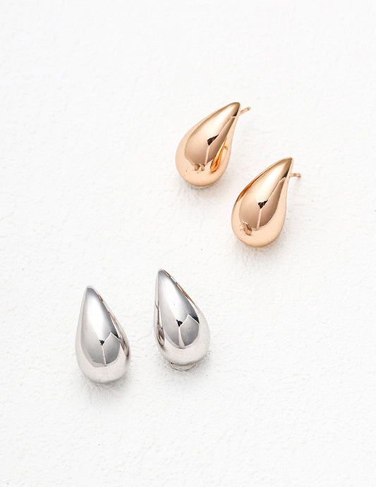 Two pairs of tear-shaped earrings in gold and silver.