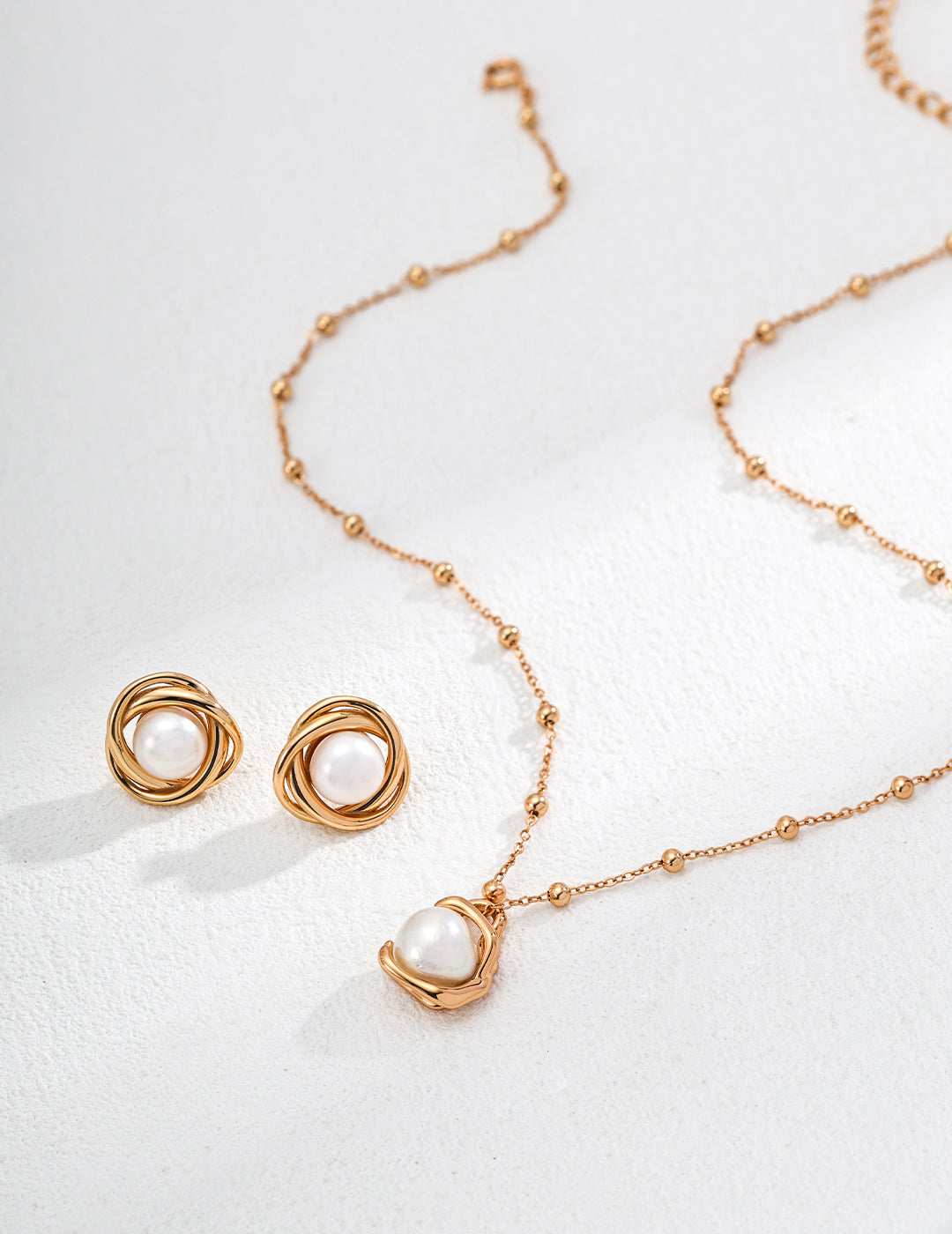 Elegant gold necklace and earrings set featuring a beautiful pearl, perfect for any special occasion.