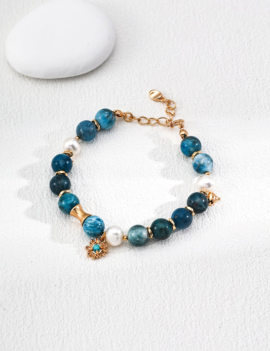 Stylish blue stone bracelet made of azurite, turquoise, and freshwater pearls, adorned with a gold-plated charm.