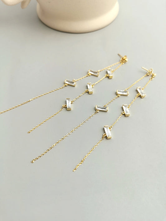 Elegant gold plated dangling earrings adorned with white cubic zirconia.