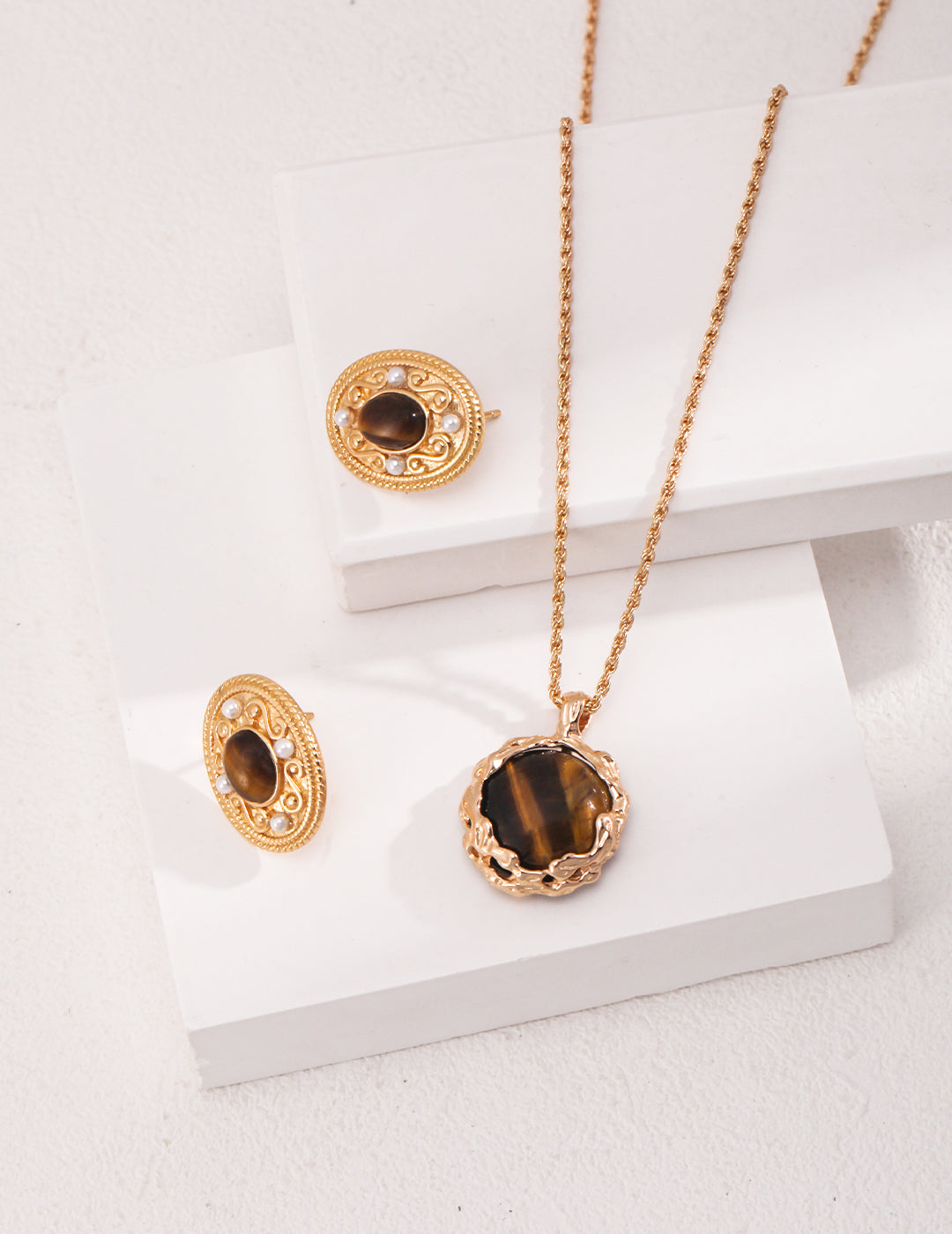 Luxurious gold necklace and earrings featuring tiger's eye stone.