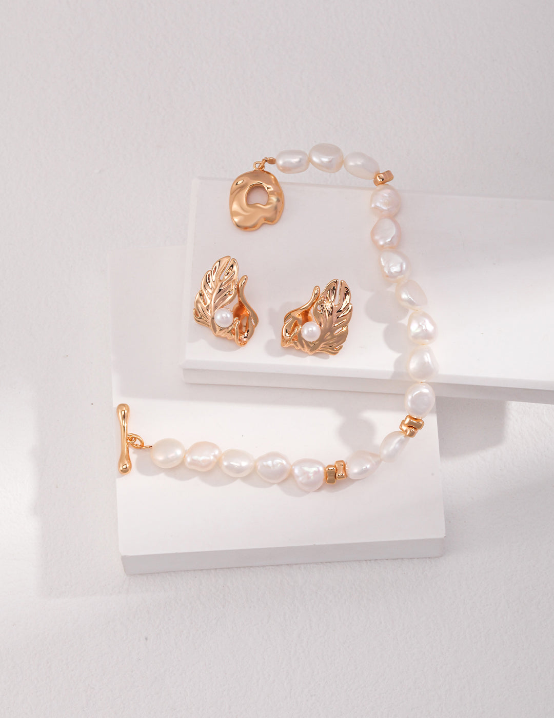 Gold bracelet and earrings with gold pearls, elegant jewelry set for a sophisticated look.