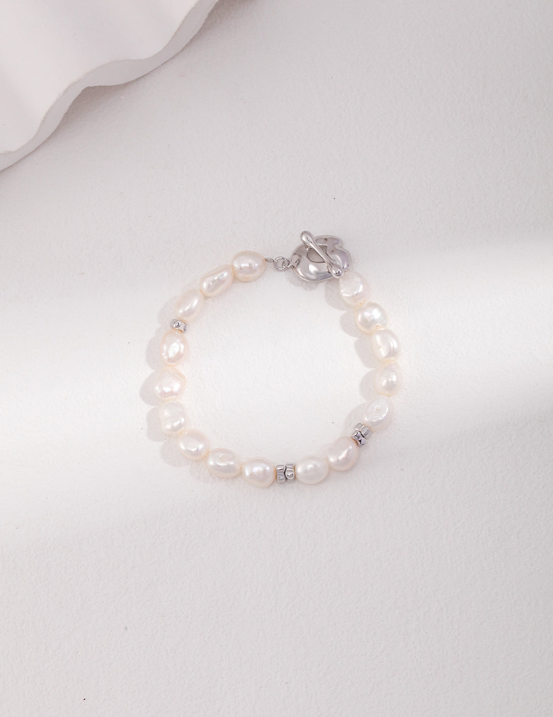 Stylish silver bracelet with white pearls and silver clasp.