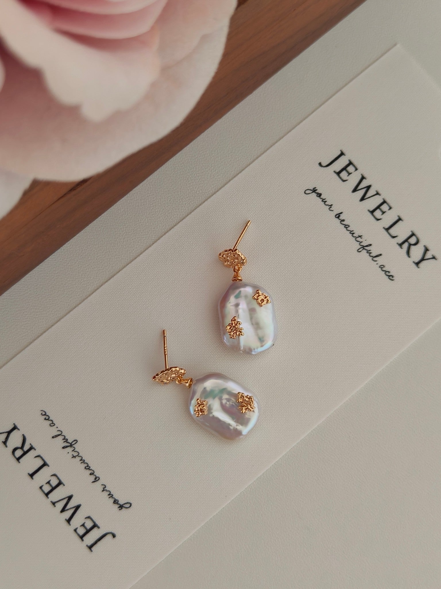 Luxurious pearl drop earrings with gold accents, by Mezuille, on a jewelry display card.