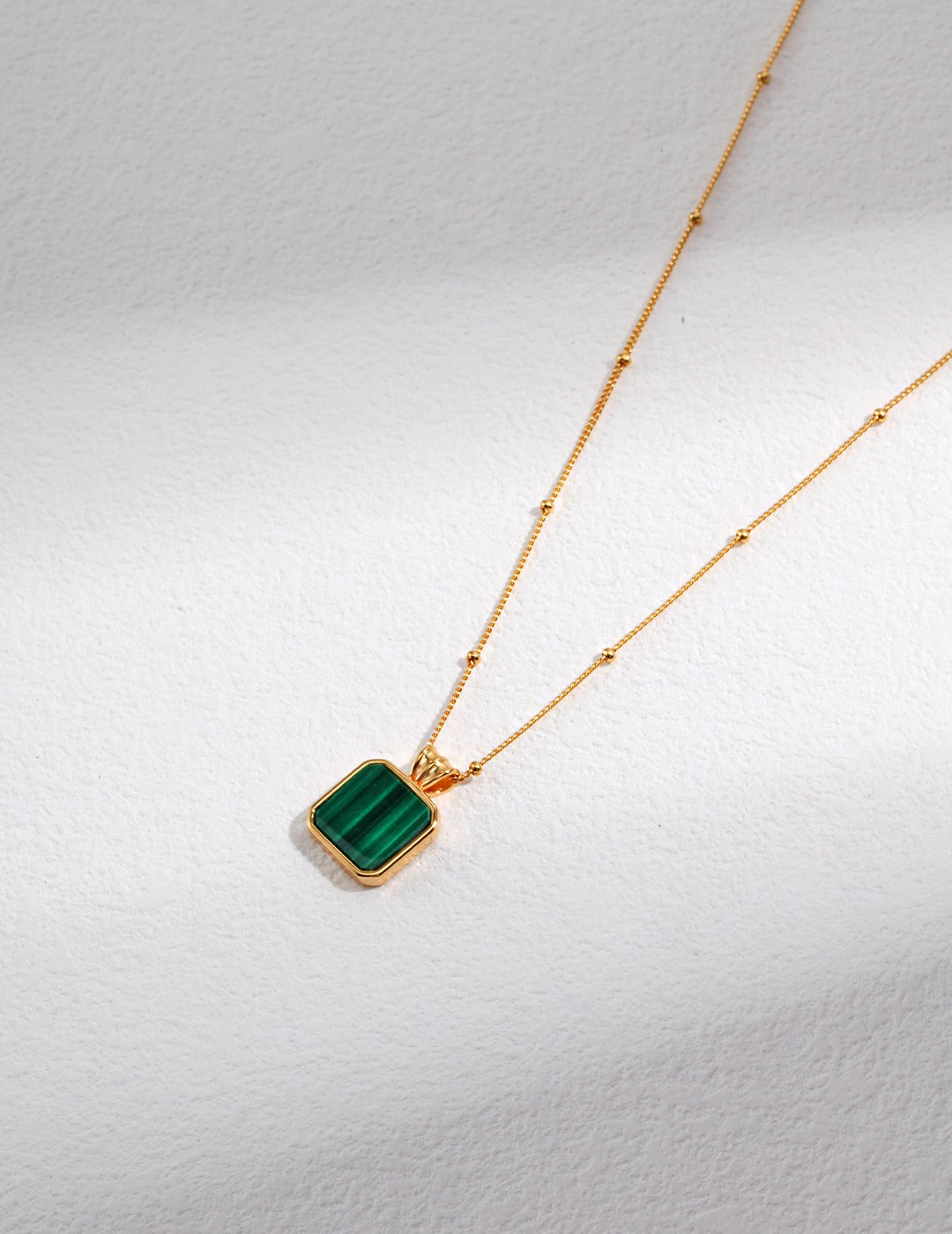 Elegant gold plated necklace adorned with a beautiful green malachite stone.