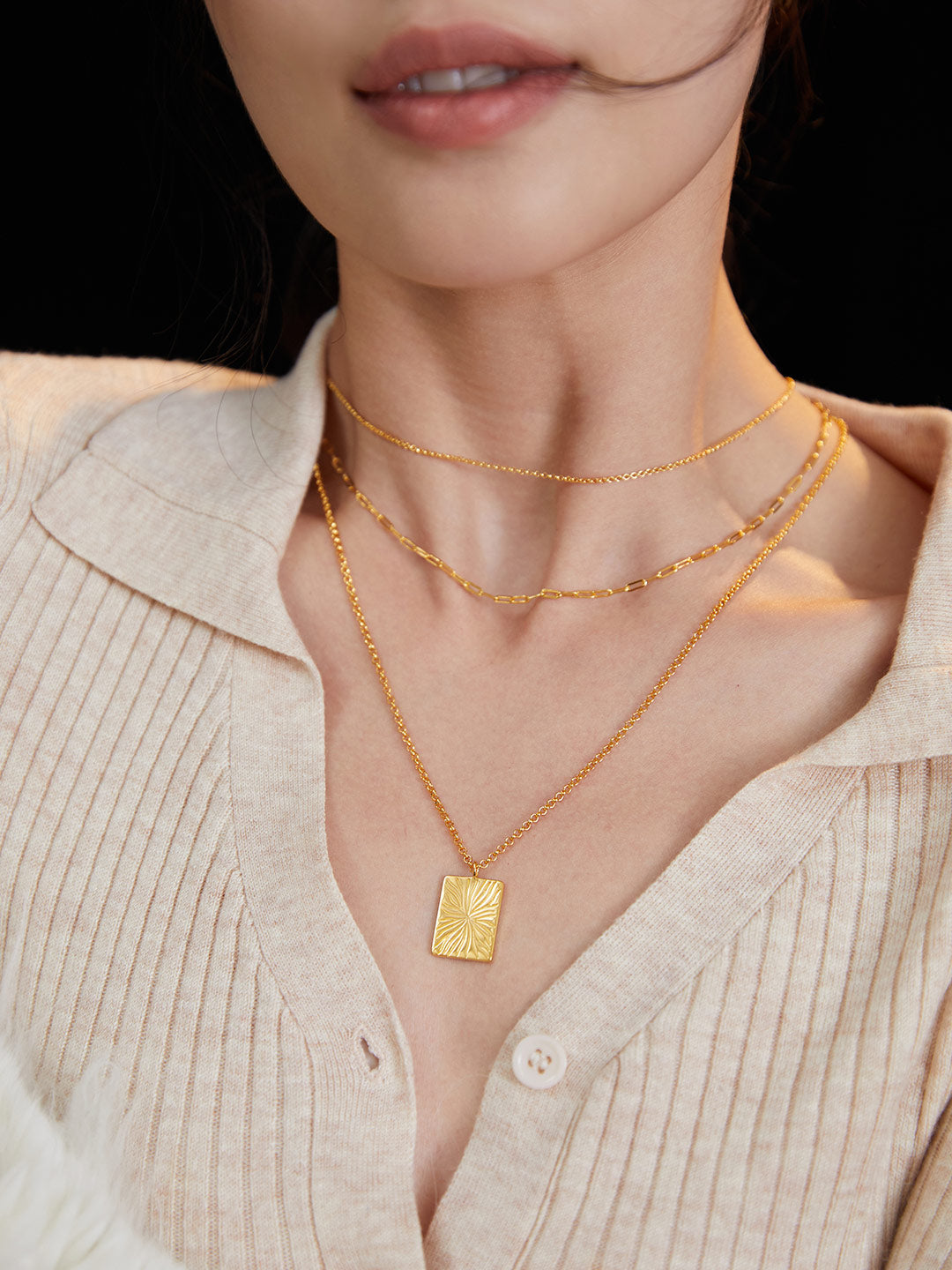 A woman wearing a gold necklace with a gold pendant, showcasing the beauty of a gold vein.