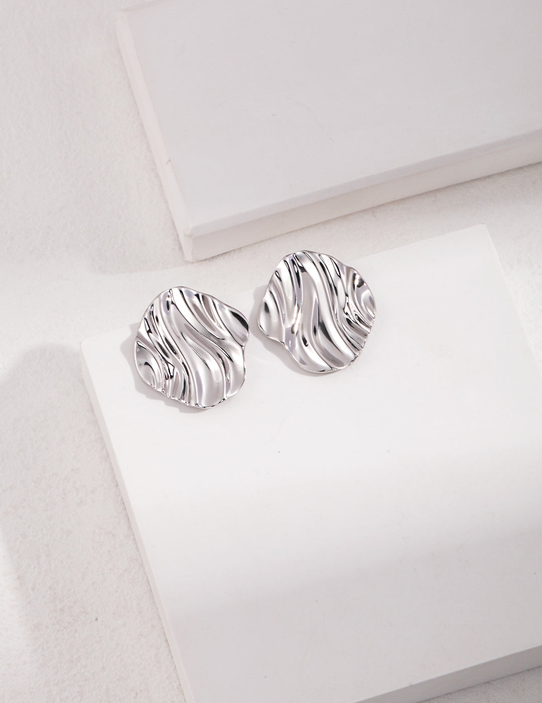 Earrings showcasing the elegant design of silver textured wave design.