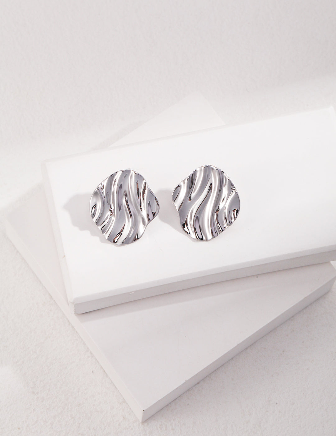 Stylish silver earrings with a wave pattern, perfect for a chic look.