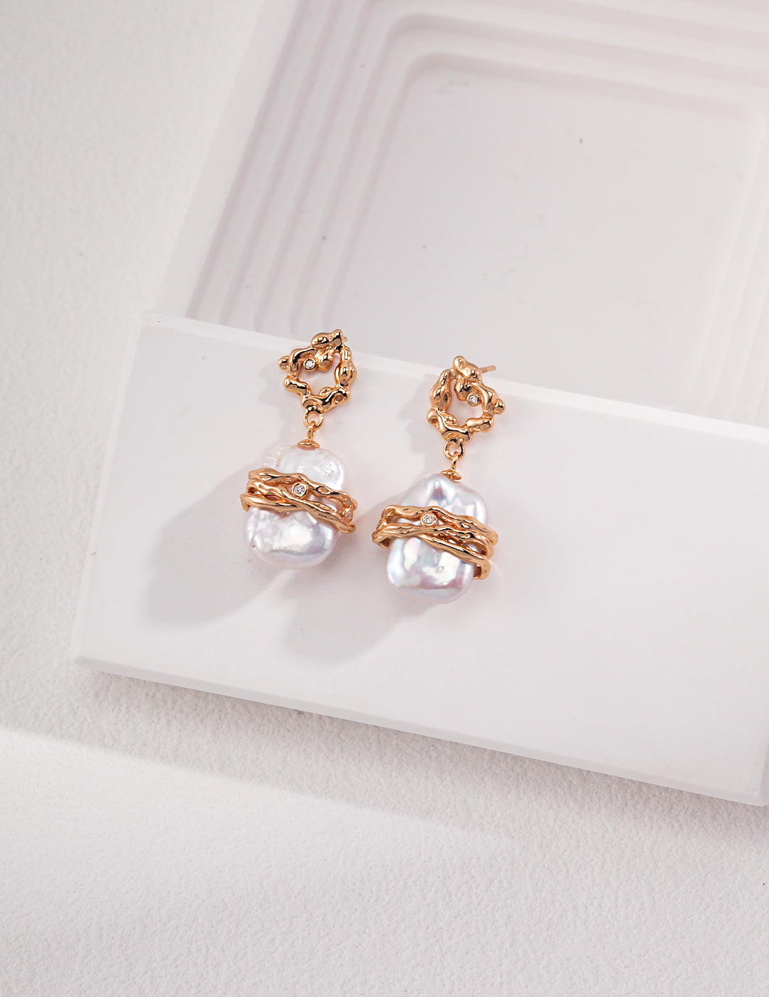 Stunning gold freshwater pearl earrings on white tray.