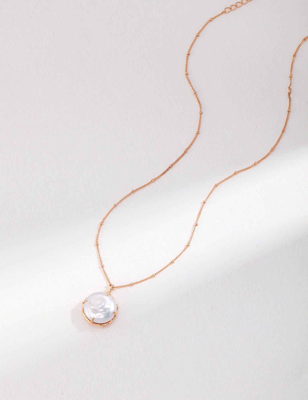 Elegant gold pearls necklace on white table