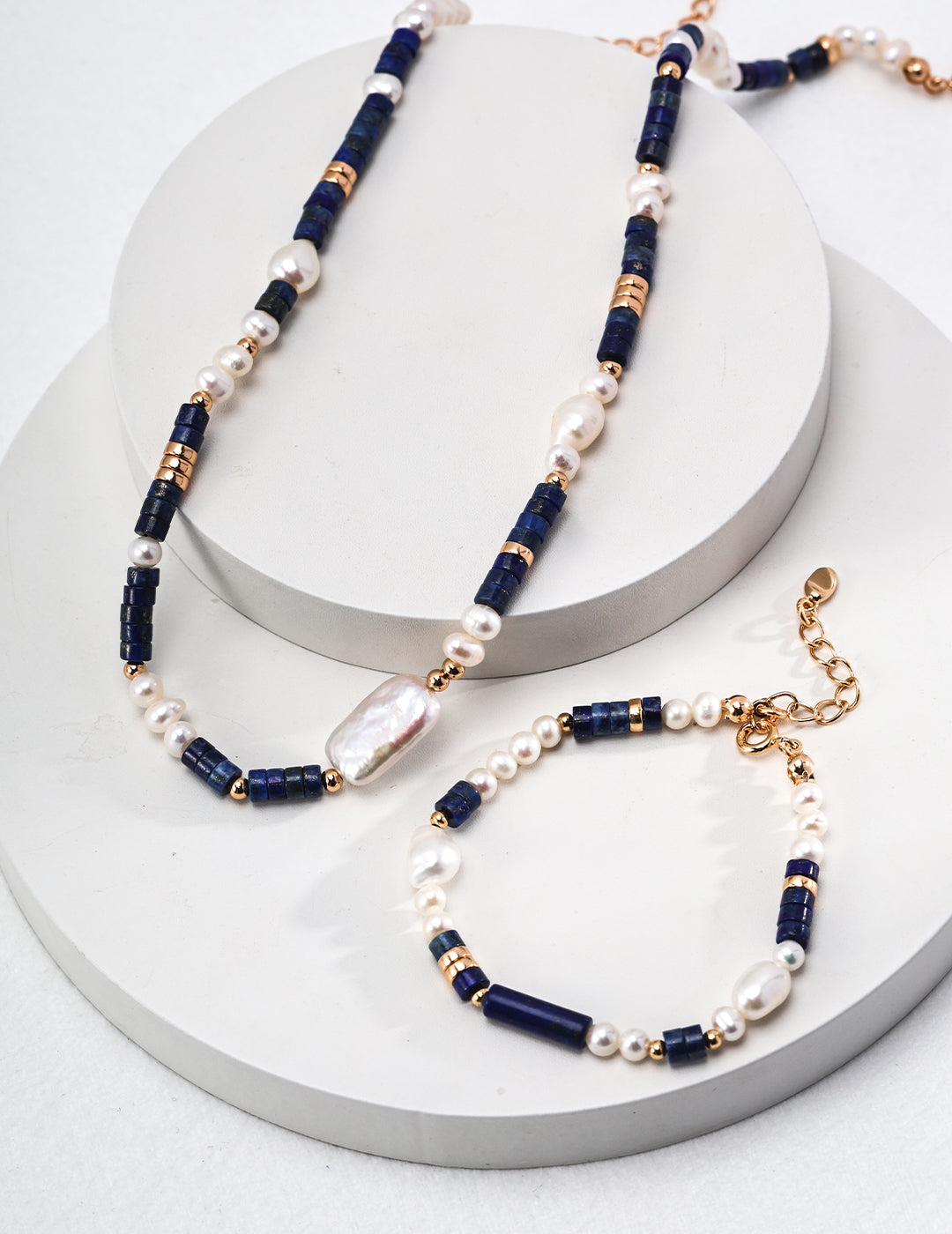 A stunning blue and white necklace and bracelet set with gold plated bracelet, freshwater pearls, and lapis lazuli.