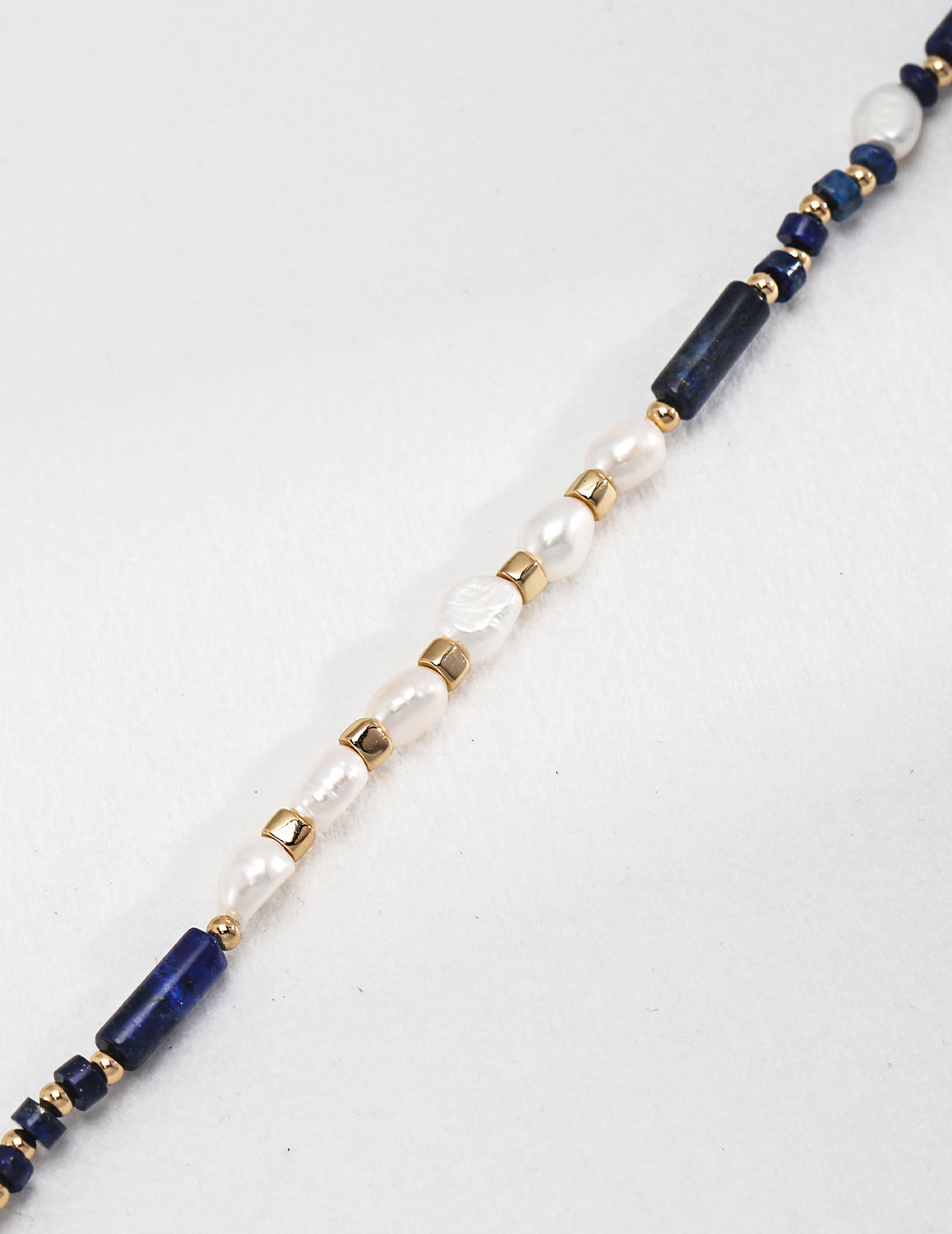 A close-up shot of a stunning necklace that features lapis lazuli stones with delicate freshwater pearls.