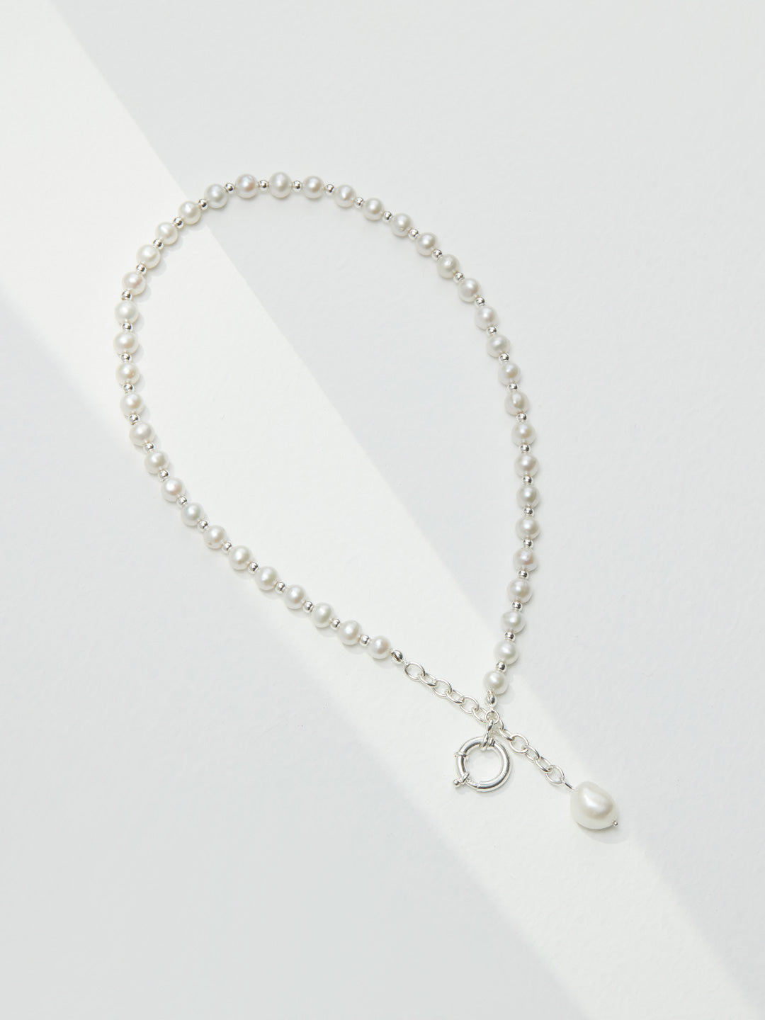 The Willow pearl necklace in S925 sterling silver, showcasing the cool-toned luster and minimalist front-toggle design.